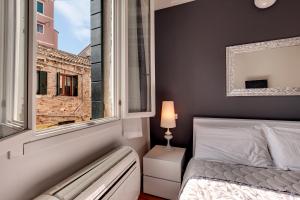 1 dormitorio con cama y ventana en Charming Castello Apartments, en Venecia