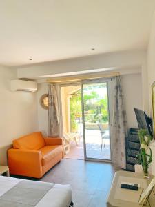 a room with a bed and a couch and a patio at Hôtel Beau Soleil in Le Lavandou