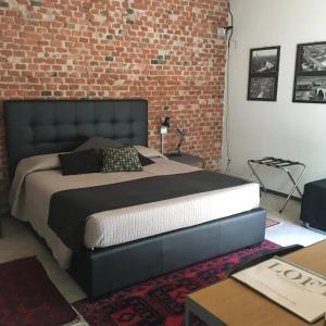 a bedroom with a large bed with a brick wall at Loft Verona in Verona