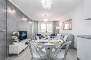 ein Esszimmer und ein Wohnzimmer mit einem weißen Tisch und Stühlen in der Unterkunft Apartments Golden Warsaw by Renters in Warschau