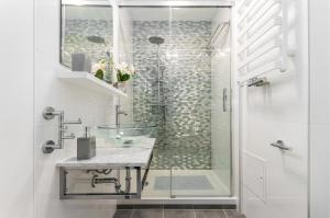 a bathroom with a glass sink and a shower at Apartments Golden Warsaw by Noclegi Renters in Warsaw