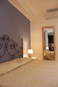 a bedroom with a bed and a mirror at La Casa dei Venti - Aeolian Charme in Canneto