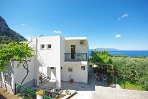 a white house with a view of the ocean at Apartmani Maslina in Gradac
