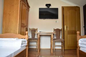 Habitación con mesa, 2 sillas y TV. en Vidikovac-Berane en Berane