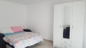 um quarto com uma cama e um armário branco em Guest House Dana em Arandjelovac