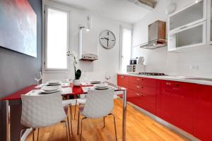 a kitchen with red cabinets and a table and chairs at Charming Castello Apartments in Venice