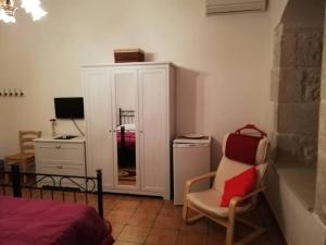 a bedroom with a chair and a desk with a computer at Torre Rocciola in Modica