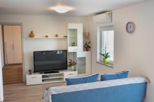 Apartmaji Hrvatin v Kortah في إيزولا: غرفة معيشة مع أريكة زرقاء وتلفزيون