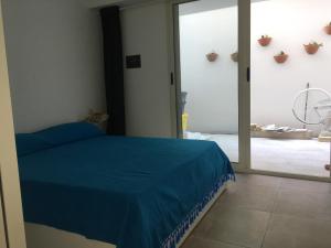 a bedroom with a blue bed and a sliding glass door at Casa in Salento a pochi passi dal mare in Santa Maria al Bagno
