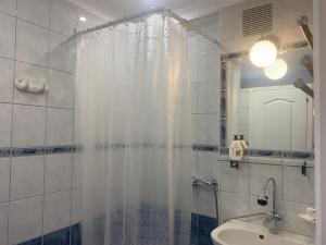 a bathroom with a shower curtain and a sink at Barbara Vendégház in Balatonfüred +56 photos