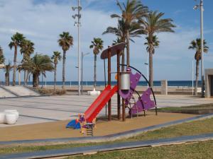 a playground at the beach with palm trees at ApartUP Patacona Beach Select in Valencia
