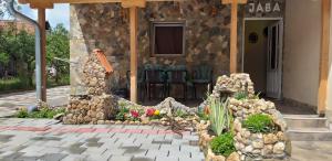 a garden of rocks and flowers in front of a house at Apartmani Java in Soko Banja