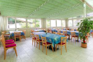 - une salle à manger avec des tables, des chaises et des fenêtres dans l'établissement Pension Kofler, à Vollan