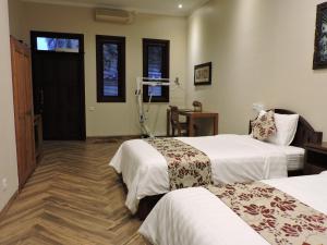 um quarto de hotel com duas camas e uma mesa em Accessible Penyaringan em Sanur
