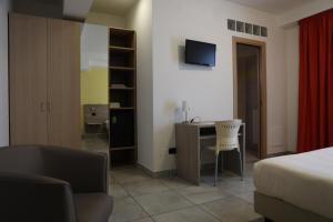 Habitación de hotel con cama, escritorio y silla en Garnì House Majorana, en Rende