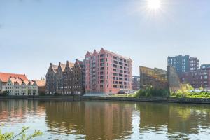 a city with tall buildings next to a river at Apartinfo Apartments Waterlane Island SPA in Gdańsk