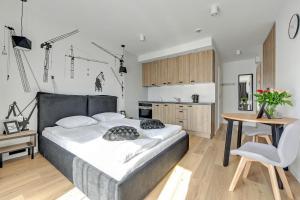 a bedroom with a large bed and a kitchen at Apartinfo Apartments Waterlane Island SPA in Gdańsk