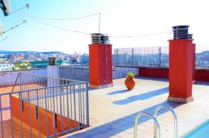 einen Balkon mit roten Säulen und einer Vase auf dem Dach in der Unterkunft V&V LLORET - APARTAMENTO BLAU precioso apartamento con piscina comunitaria, parking y aire acondicionado Solo se aceptan familias in Lloret de Mar