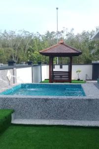 una piscina con cenador en el patio trasero en Jauzara Homestay Berkolam Renang, en Port Dickson