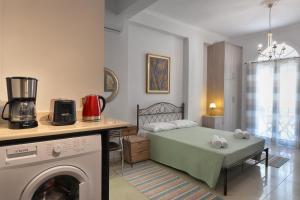 a small room with a bed and a table with a drying machine at Milonas Studios in Corfu