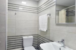 a bathroom with a toilet and a sink and a mirror at Milonas Studios in Corfu