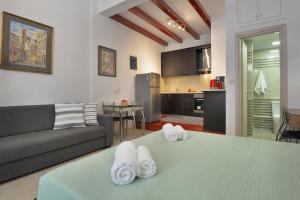 a living room with a couch and a table with towels at Milonas Studios in Corfu