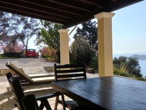 アフィオナスにあるHoliday home with stunning views near Afionasの木製テーブルと椅子が備わる眺めの良いパティオ