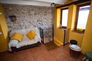 a living room with a couch with yellow pillows at El Portal de Vilafamés in Vilafamés