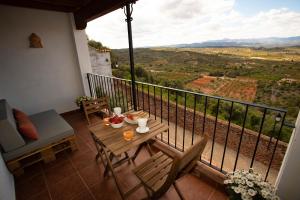 een tafel en stoelen op een balkon met uitzicht bij El Portal de Vilafamés in Vilafames