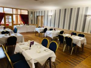 une salle à manger avec tables et chaises et nappes blanches dans l'établissement The Bannville Hotel, à Banbridge