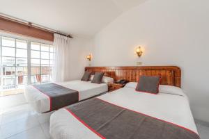 2 camas en una habitación con ventana en Hotel Casa Marín, en A Revolta
