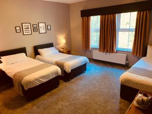 um quarto com 2 camas e 2 janelas em The Bannville Hotel em Banbridge