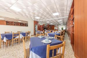 comedor con mesas azules y sillas de madera en Hotel Casa Marín, en A Revolta