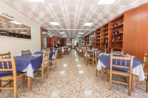 un comedor con mesas y sillas azules en Hotel Casa Marín, en A Revolta