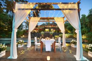 a table and chairs under a gazebo with lights at Jannata Resort and Spa in Ubud