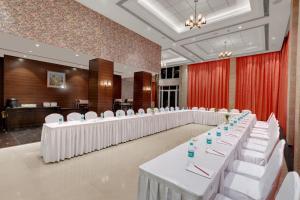 une salle de conférence avec des tables et des chaises blanches dans l'établissement The Fern Residency, Satara Maharashtra, à Satara