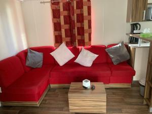 un sofá rojo en una sala de estar con mesa en Dream holidays, en Valras-Plage