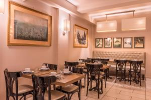 a restaurant with tables and chairs and a bench at Paris France Hotel in Paris