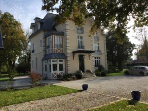 a house with a car parked in front of it at Manoir des Logis in Yvré-lʼÉvêque