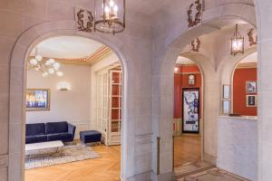 a living room with arches and a blue couch at Paris France Hotel in Paris