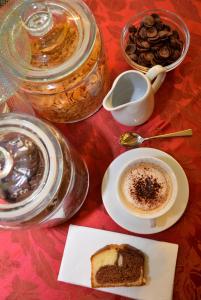 una mesa con una taza de café y un trozo de tarta en Hotel Salieri, en Legnago