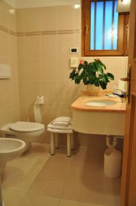baño con lavabo, aseo y planta en Albergo Dolomiti, en Capriana