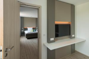 a room with a bed and a door with a television at Motel B in Bocholt