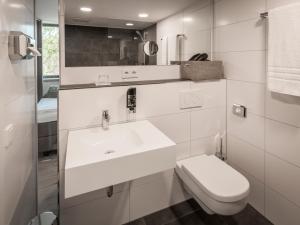a white bathroom with a sink and a toilet at Motel B in Bocholt +6 photos