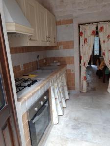 アルベロベッロにあるAlberobello Casa Vacanze - Pathos tra i Trulliのキッチン(コンロ、シンク付)