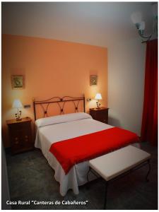 a bedroom with a large bed with a red blanket at Casa Rural Las Canteras de Cabañeros in Retuerta de Bullaque