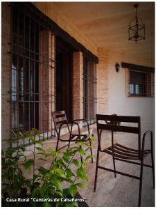 two chairs sitting on the porch of a building at Casa Rural Las Canteras de Cabañeros in Retuerta de Bullaque