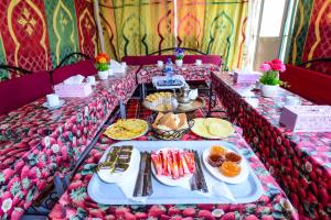 Hôtel Faouzi في مراكش: طاولة طويلة مع طعام في الأعلى