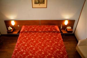 レニャーゴにあるオテル サリエリの赤いベッド1台(赤い毛布付)が備わるベッドルーム1室が備わります。