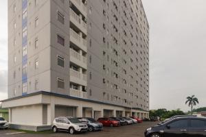 um grande edifício com carros estacionados num parque de estacionamento em RedDoorz Apartment @ Dramaga Tower em Bogor